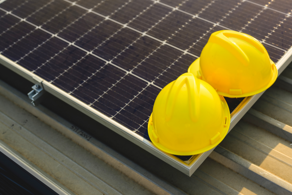 deux casques de chantier jaune posés sur des panneaux solaires