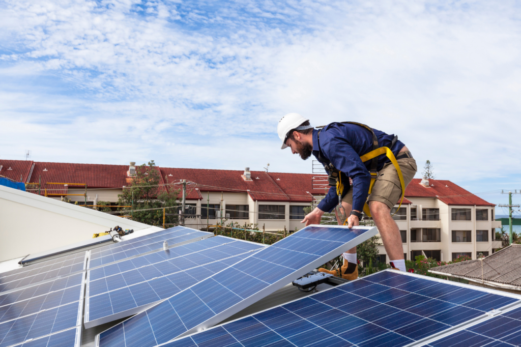 équipier qui installe un panneau solaire sur un toit
