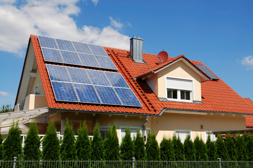 maison avec une toiture rouge où sont posés des panneaux solaires