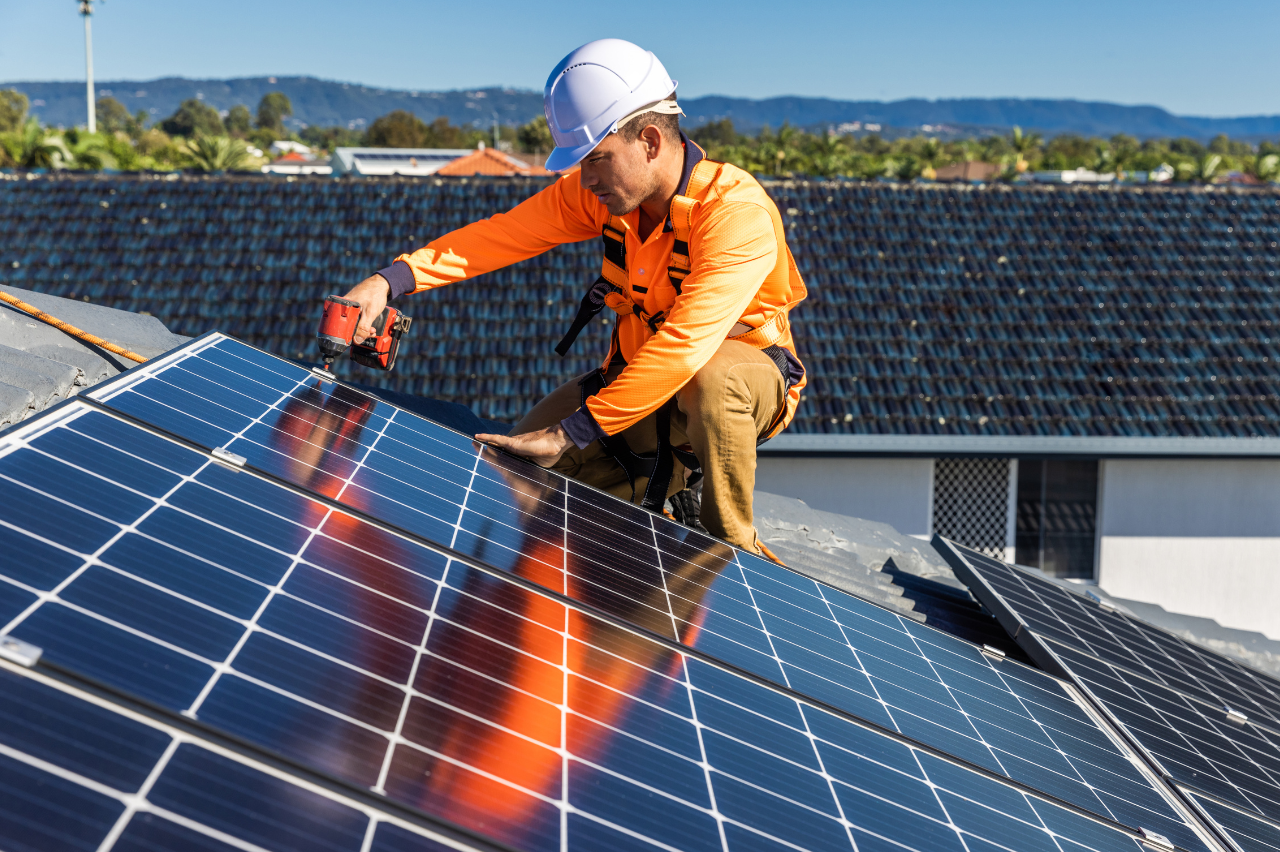artisan qui visse un panneau solaire