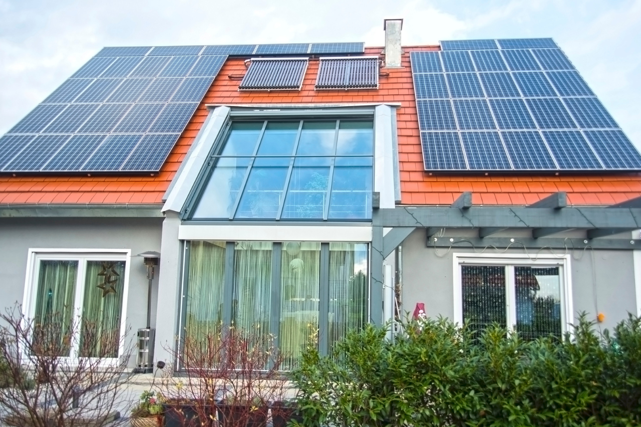 façade d'une maison où sont posés des panneaux solaires sur le toit