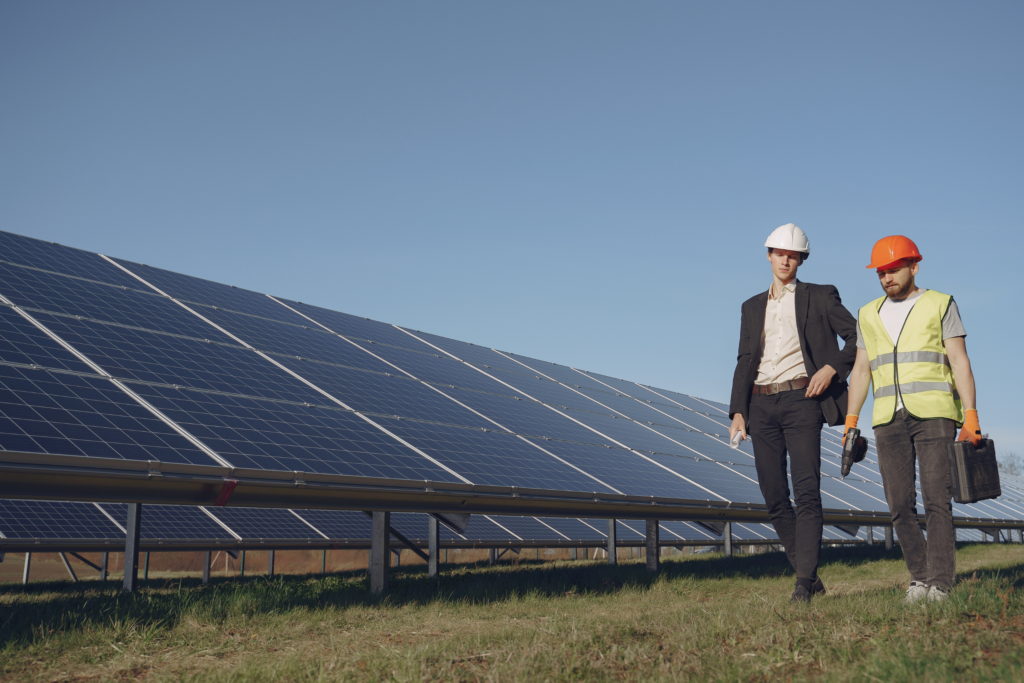 un employé et un client qui marchent près de panneaux solaires sur le sol